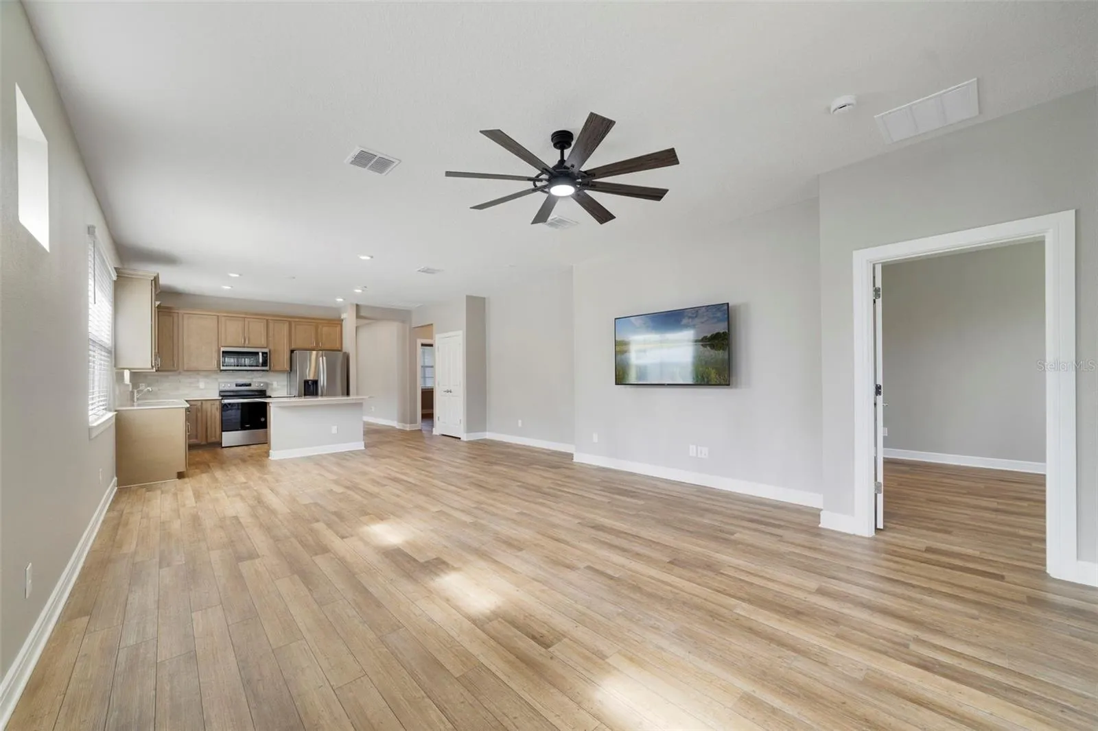 HUGE living/dining room combo with a ceiling fan and the mounted TV is included
