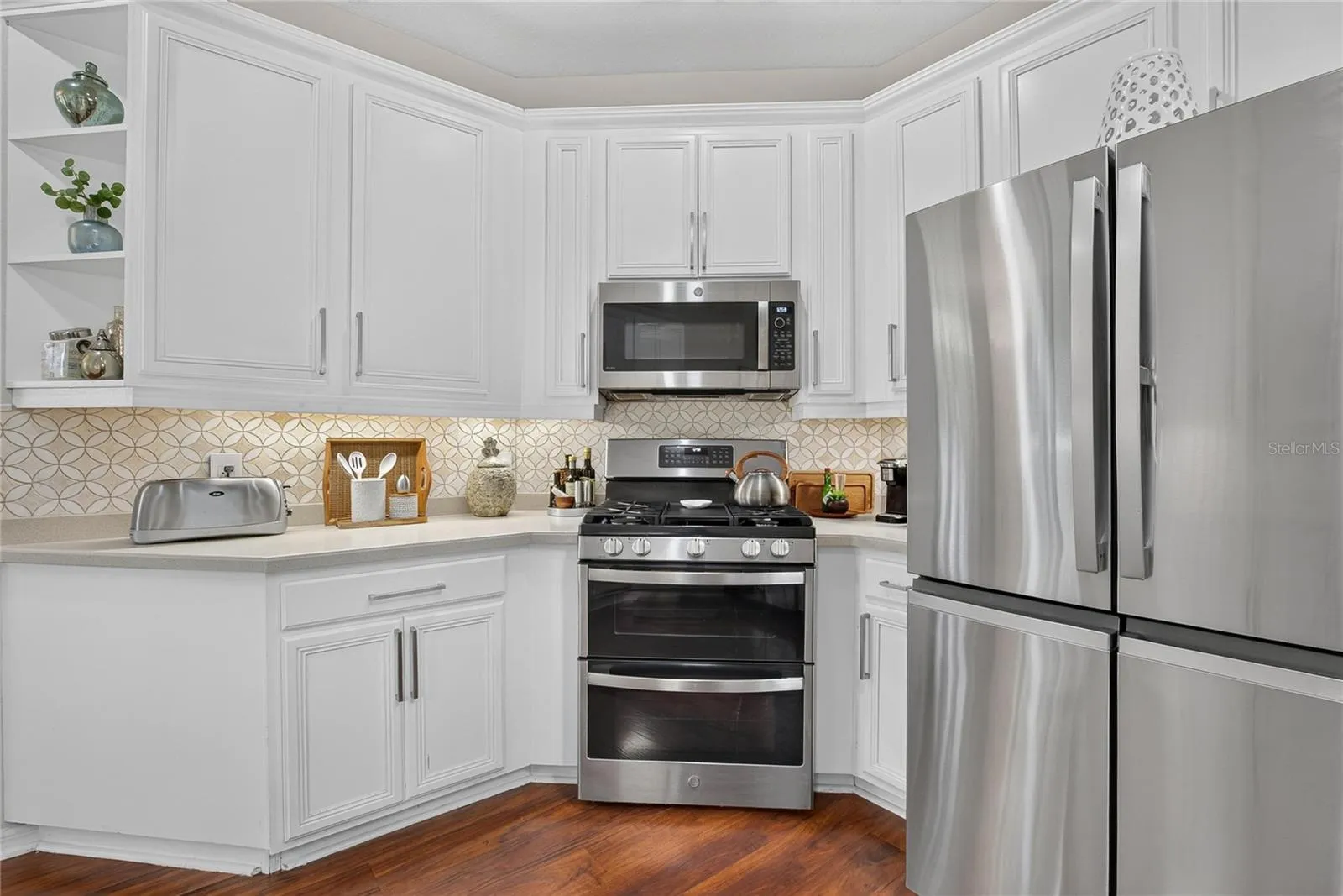 Bright kitchen with breakfast bar, abundant cabinetry, generous counter space, gas range and newer stainless steel appliances.