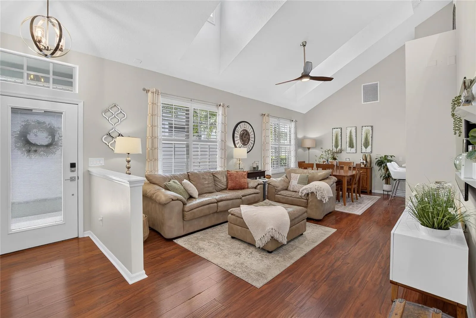 Light-filled living and dining area with soaring ceilings and dormer windows.