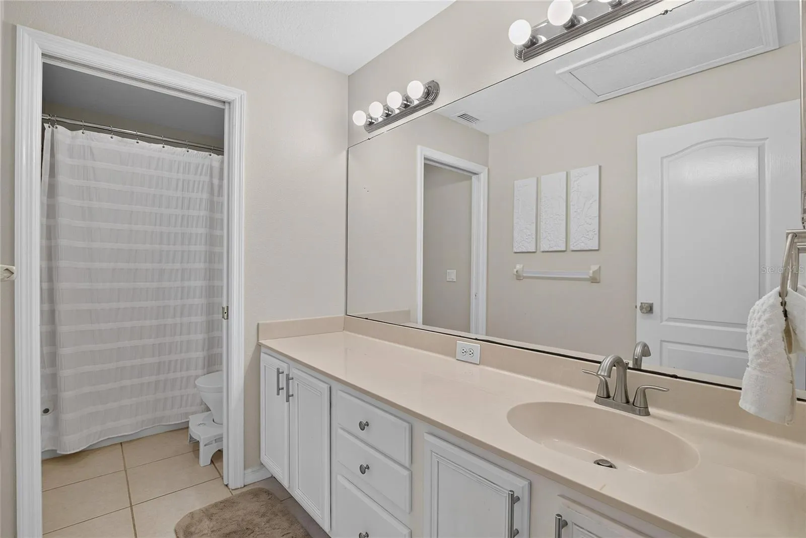 Upstairs full bath with spacious vanity, abundant cabinetry and tub/shower combination.