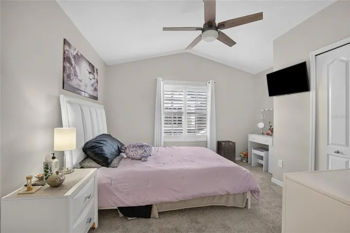 Generously sized secondary bedroom with vaulted ceiling, plantation shutters and ample closet space.