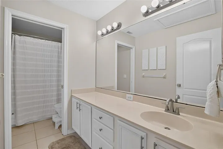 Upstairs full bath with spacious vanity, abundant cabinetry and tub/shower combination.