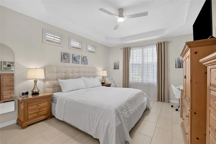 Spacious first-floor primary suite with tray ceiling, plantation shutters and abundant natural light.