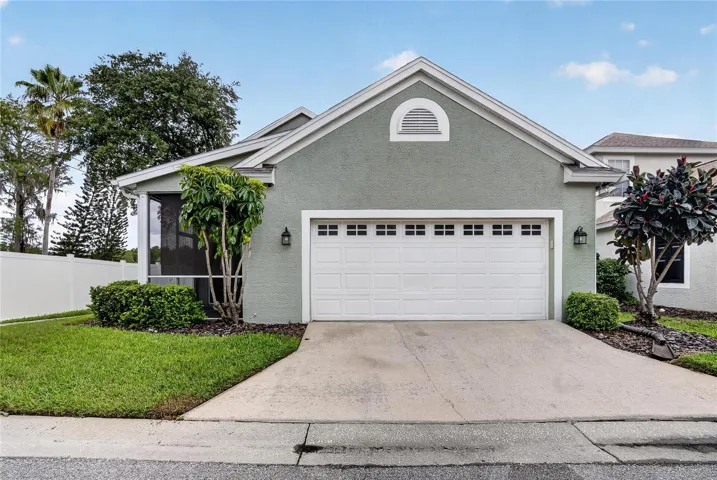 Rear-load two-car garage with screened lanai conveniently tucked alongside the home.