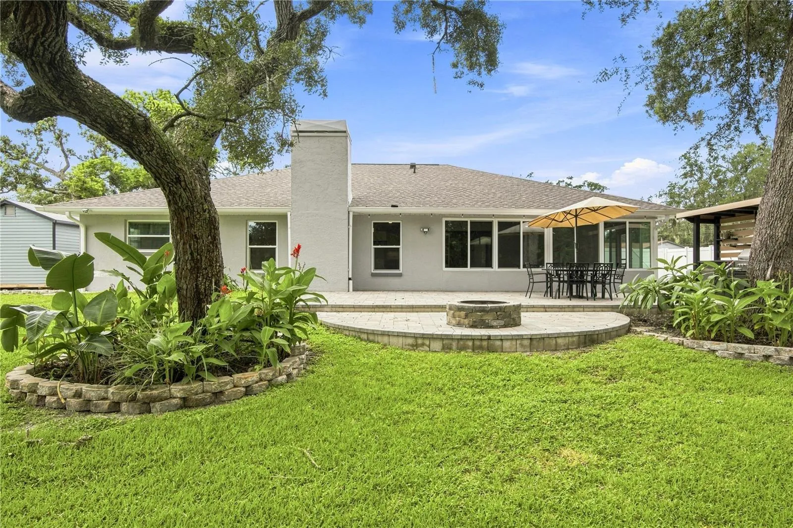 Welcome to your backyard oasis with outdoor kitchen, fire pit, and 5 garden beds for growing your own food!