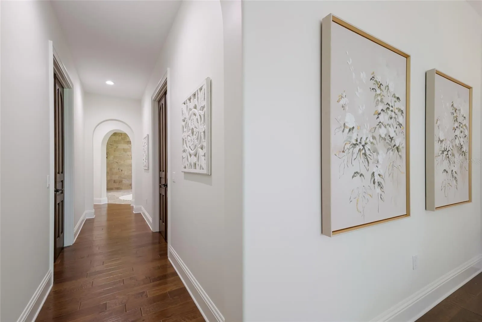 Hall from primary bedroom to en suite bath, dual dressing rooms on right and left