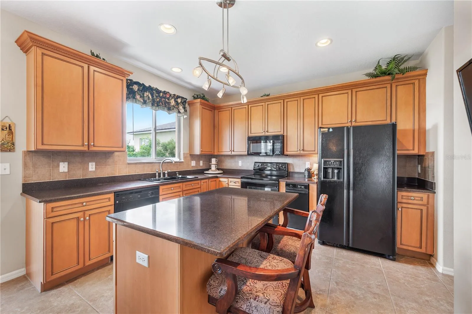 The kitchen is sunny &amp; bright . Surrounded by solid wood cabinetry with plenty of storage , granite countertops, a breakfast Bar , along with a view of Island Lake and the 15th hole
