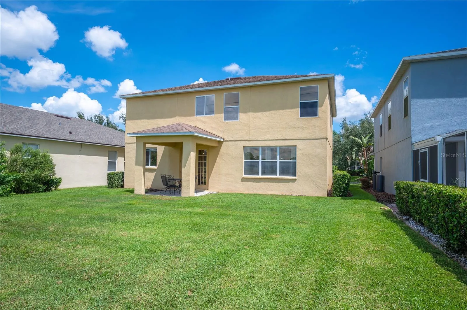 A rear view of the home and its covered rear patio , perfect for enjoying morning coffee or evening sunsets