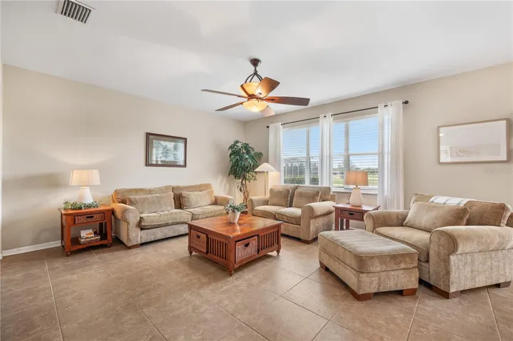 The Family room is over sized, features tall ceilings, tile flooring and a stunning view of the Golf Course &amp; Island Lake