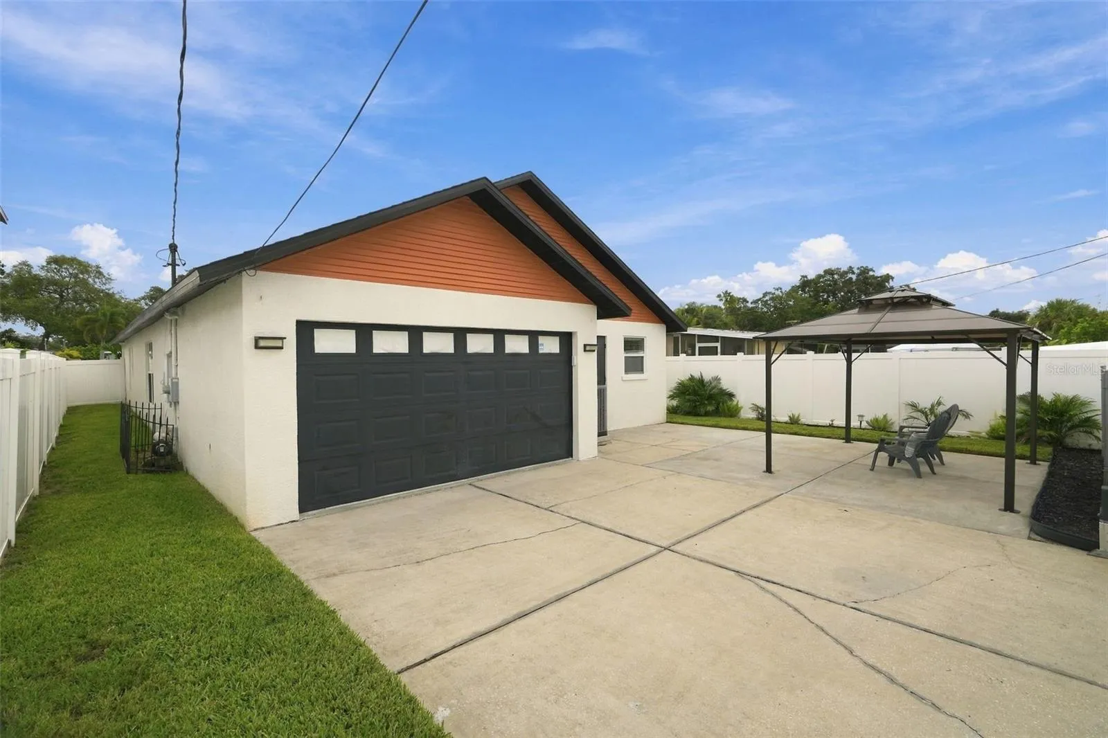 Desirable alley access through a remote-controlled electric gate leads to the two-car garage, adding both privacy and convenience.