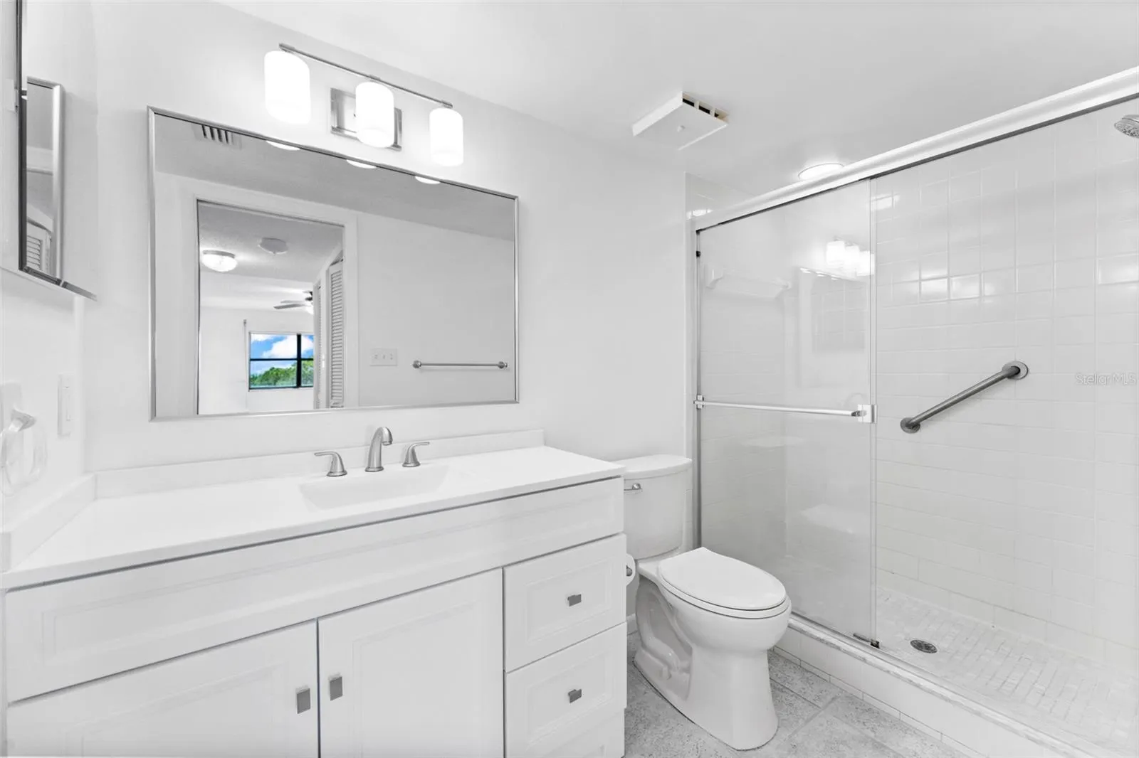 Primary bathroom with new vanity, lighting and toilet.