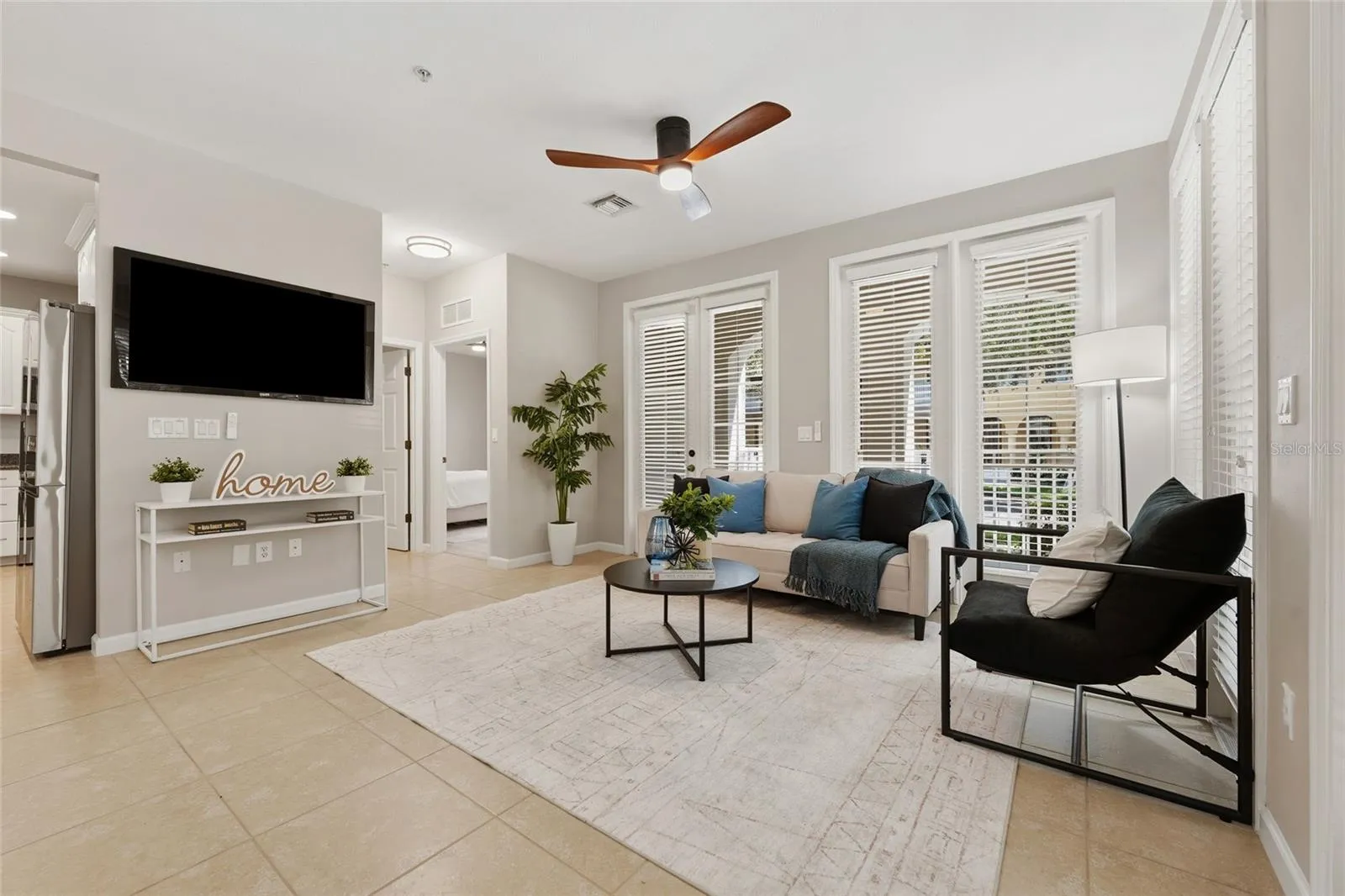 Bright, open living area surrounded by windows and French doors, bringing in abundant natural light.