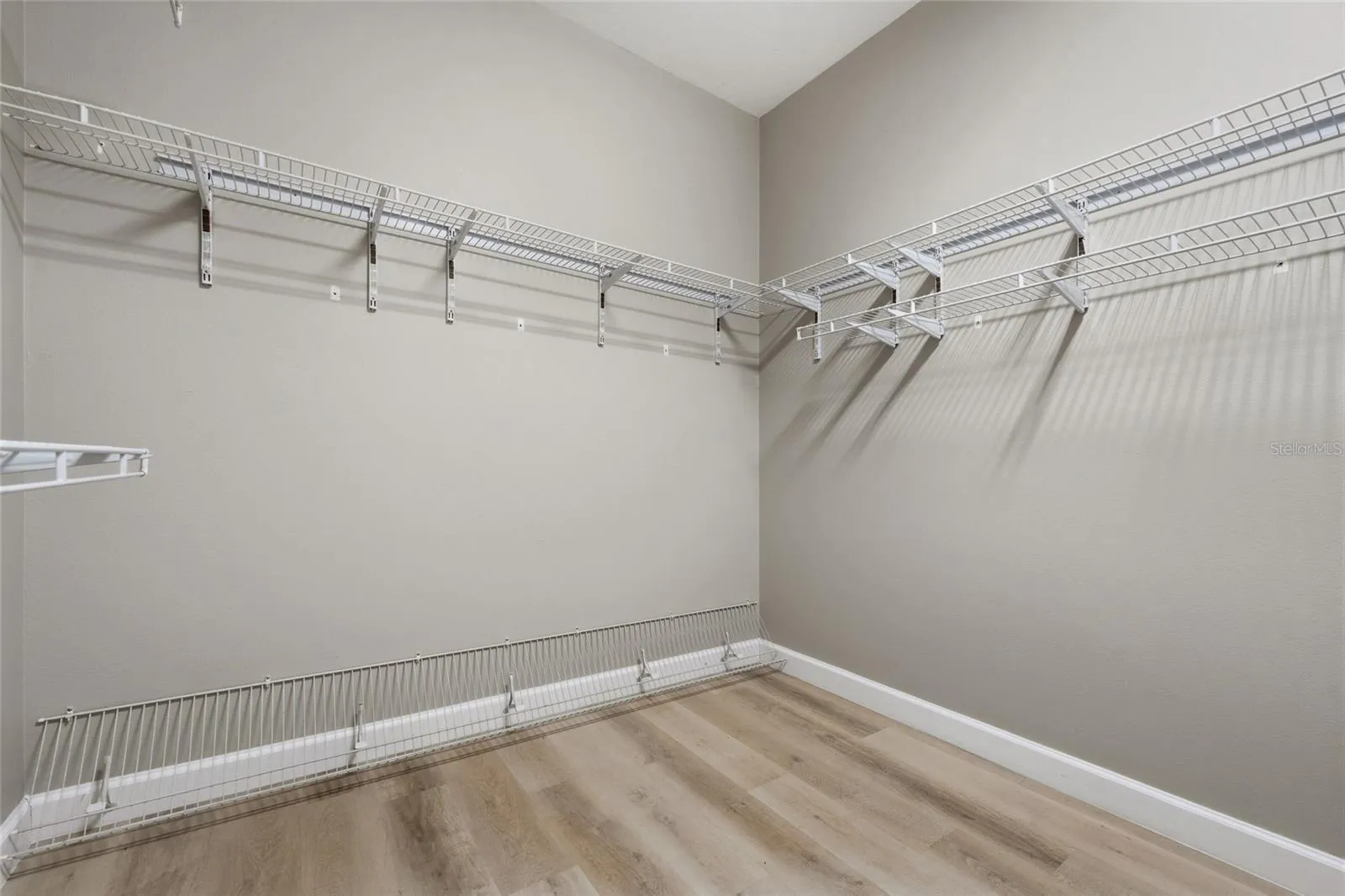 Large walk-in primary closet provides excellent storage with wraparound shelving.