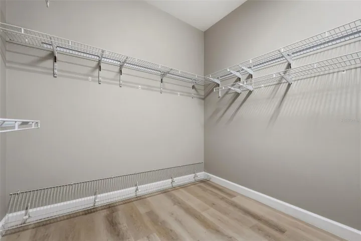 Large walk-in primary closet provides excellent storage with wraparound shelving.