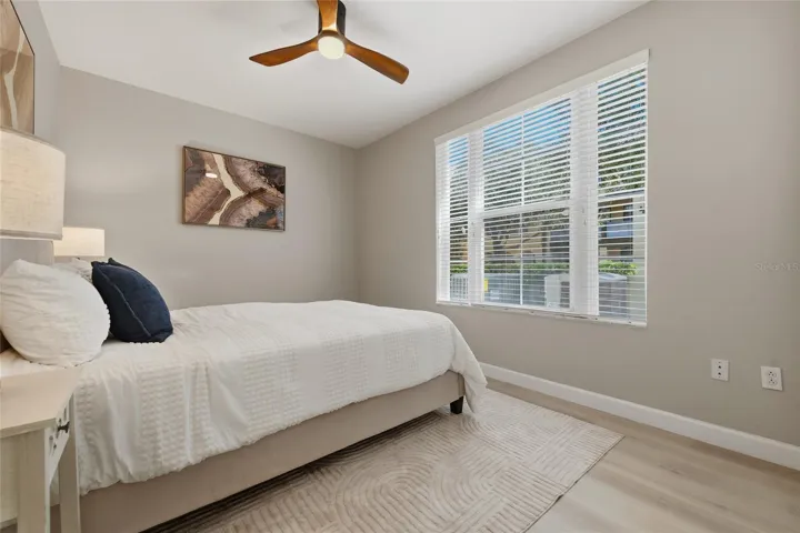 Bright secondary bedroom with updated flooring, ceiling fan and generous natural light.