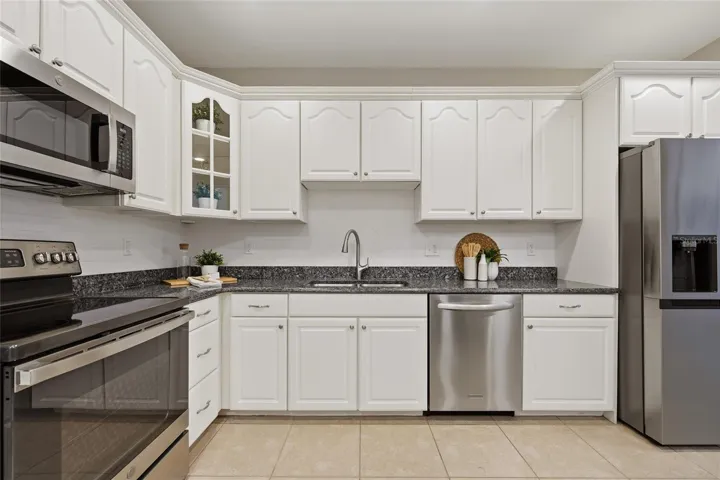 Crisp white cabinetry, granite countertops, tile backsplash and stainless-steel appliances complete the spacious kitchen.