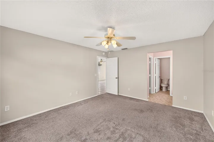 Standing in the corner of the primary bedroom facing the hall and bathroom.