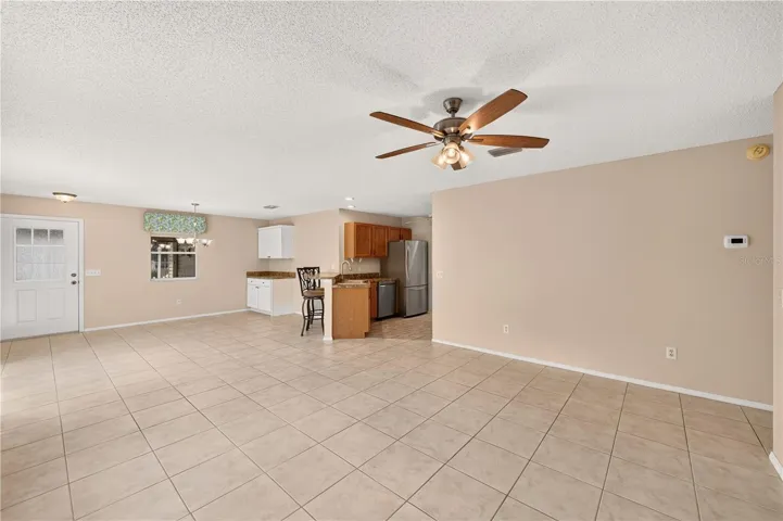 Standing in the corner of the living room looking toward the dining room and kitchen.