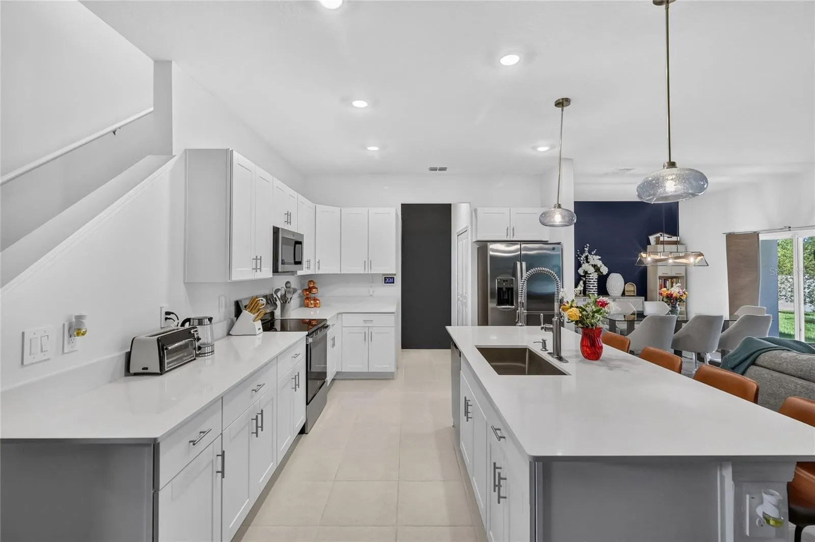 Quartz counter tops and tile floors in the kitchen.  Open concept with large island.