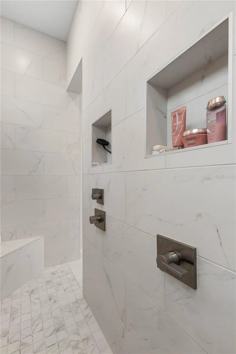Convenient built-in storage shelves in the walk-through shower