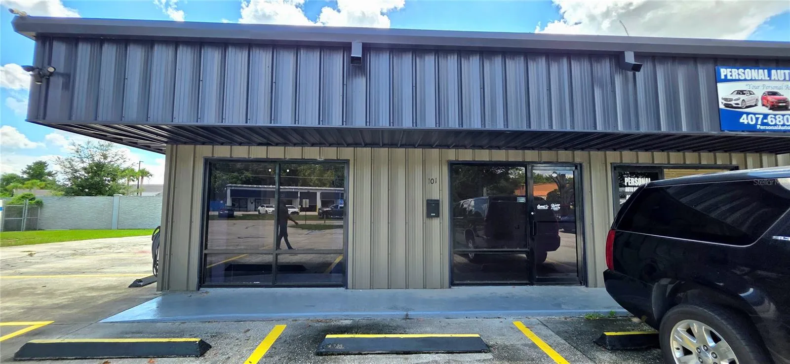 Front view of the offices with floor-to-ceiling windows and glass door. Shared customer parking on-site