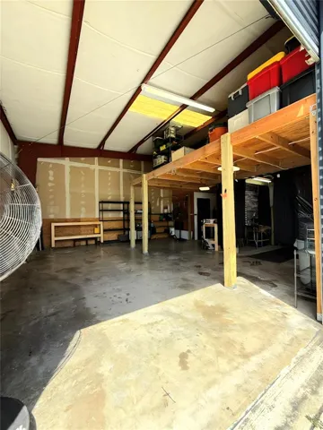View from the roll up door into the bay area. Additional storage with lighting under loft