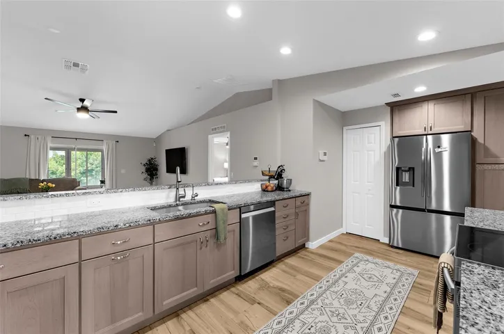 Functional kitchen with abundant cabinetry, generous counter space, and wood look tile flooring.