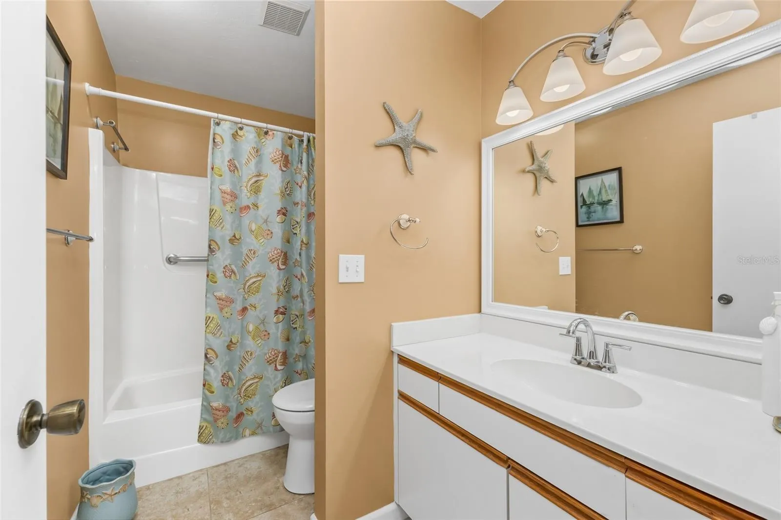 The private primary bath offers a spacious vanity with generous counter space, a large wall mirror and a tub/shower combination—all conveniently tucked within the primary suite.