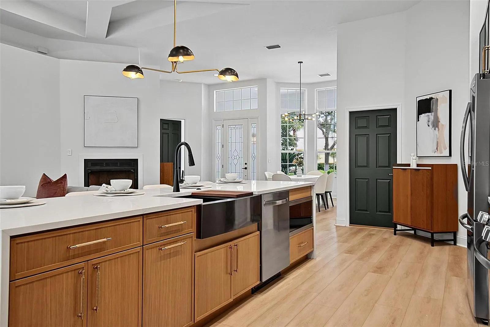 The beautiful crafted wood cabinets frame the sleek design of the black fixtures, farm house sink, inset microwave and dishwater.