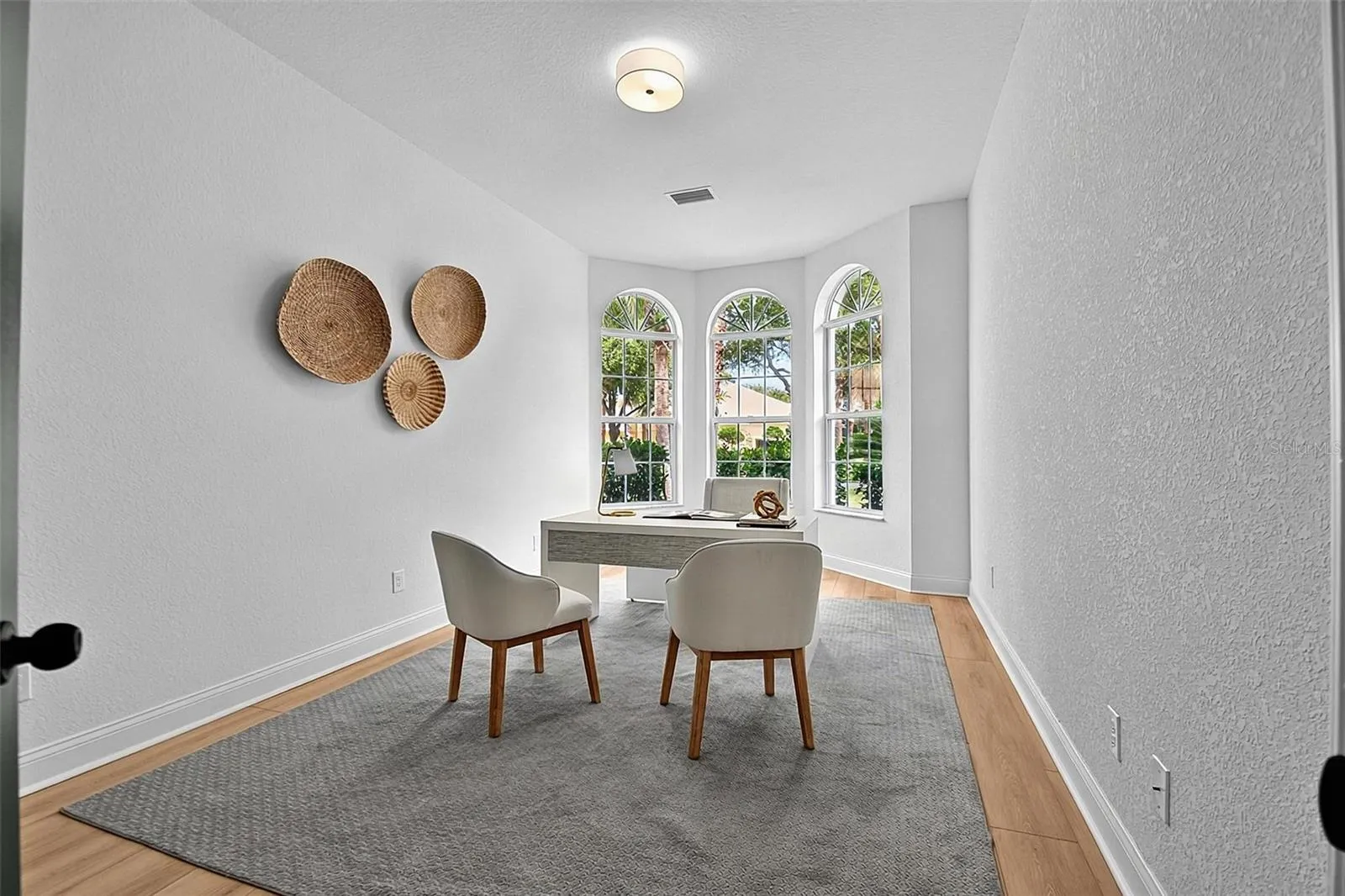 The 2nd guest bedroom features high curved Bay area windows giving lots of natural light. This bedroom can be used as an office shown here or a den.