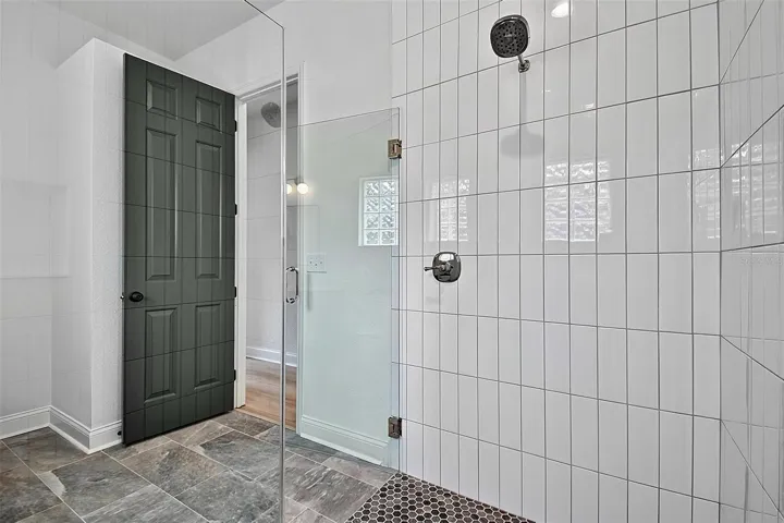 The 2nd guest bathroom shows the new glass surround for the huge new tiled shower and penny tiled shower flooring