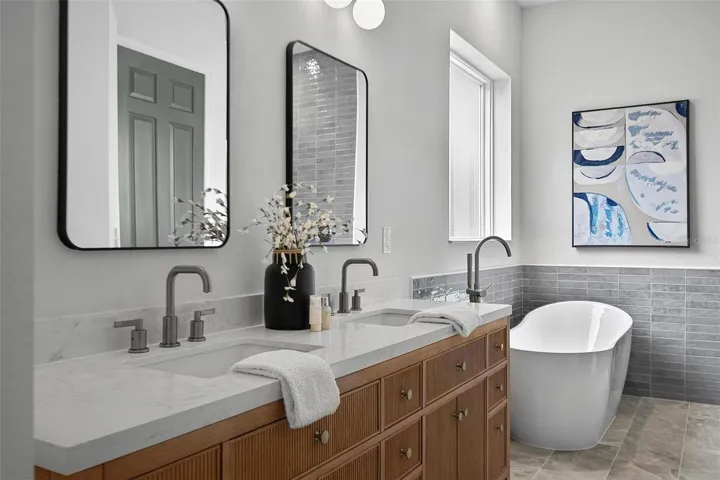 The luxurious en-suite master bath features a freestanding soaking tub, separate tiled shower with niches and a walk-in closet. The double sink wood vanity, new mirrors, new fixtures and new lighting lends to the special designer touches