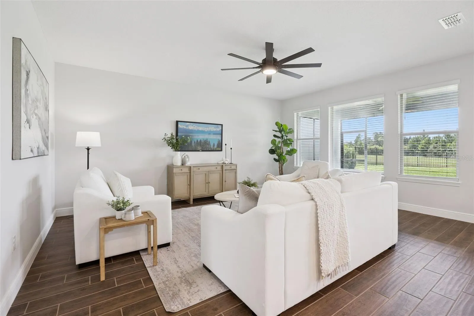 Living room with ceiling fan and pond-view windows