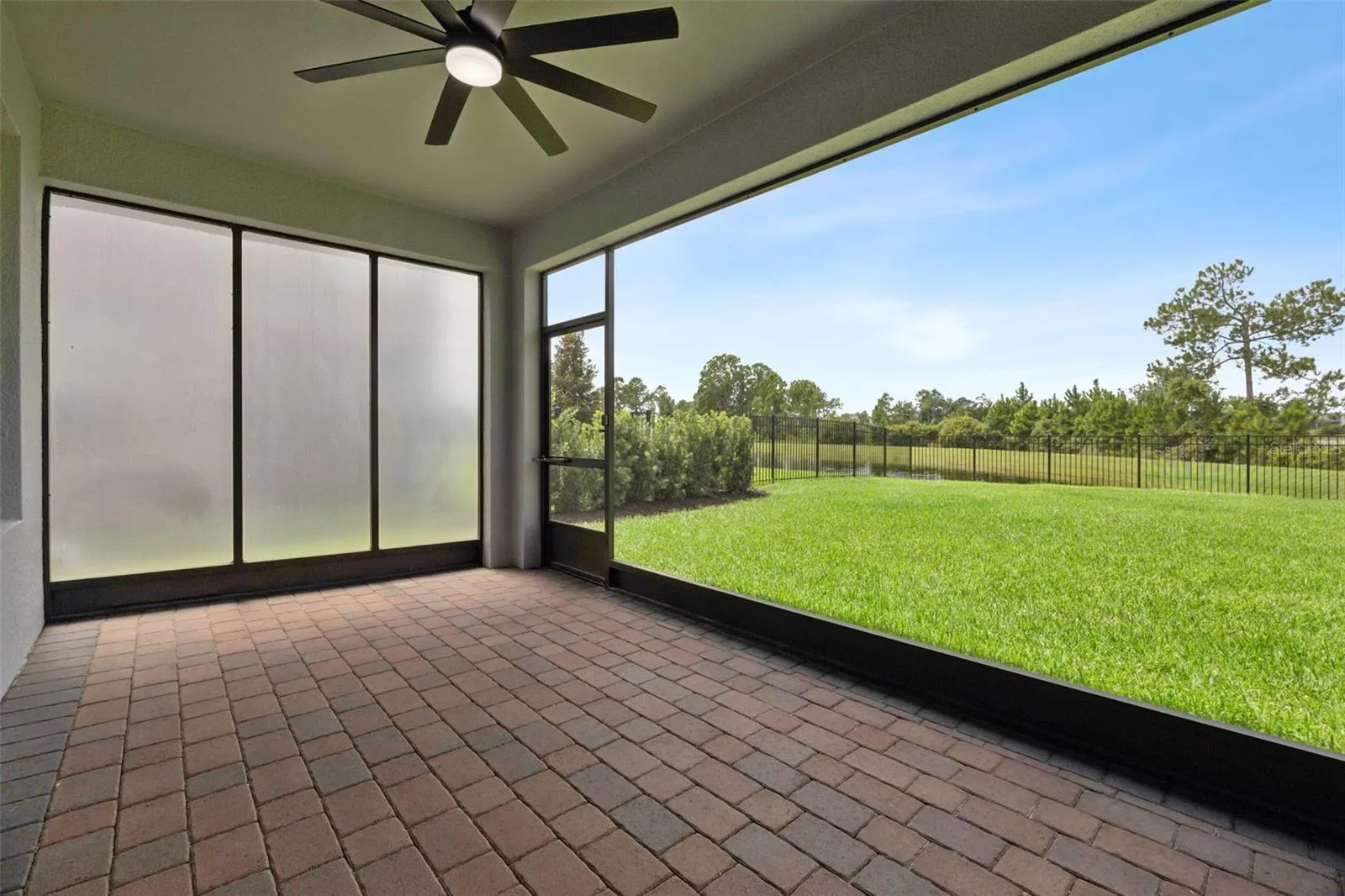 Screened lanai overlooking the fenced yard and conservation