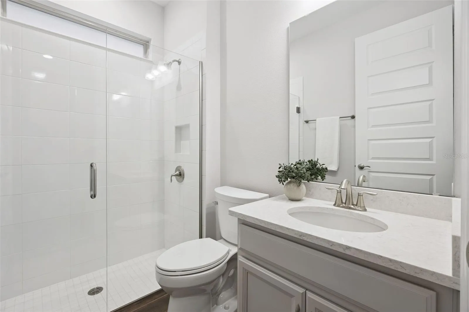 First-floor full bath with walk-in shower and quartz-topped vanity