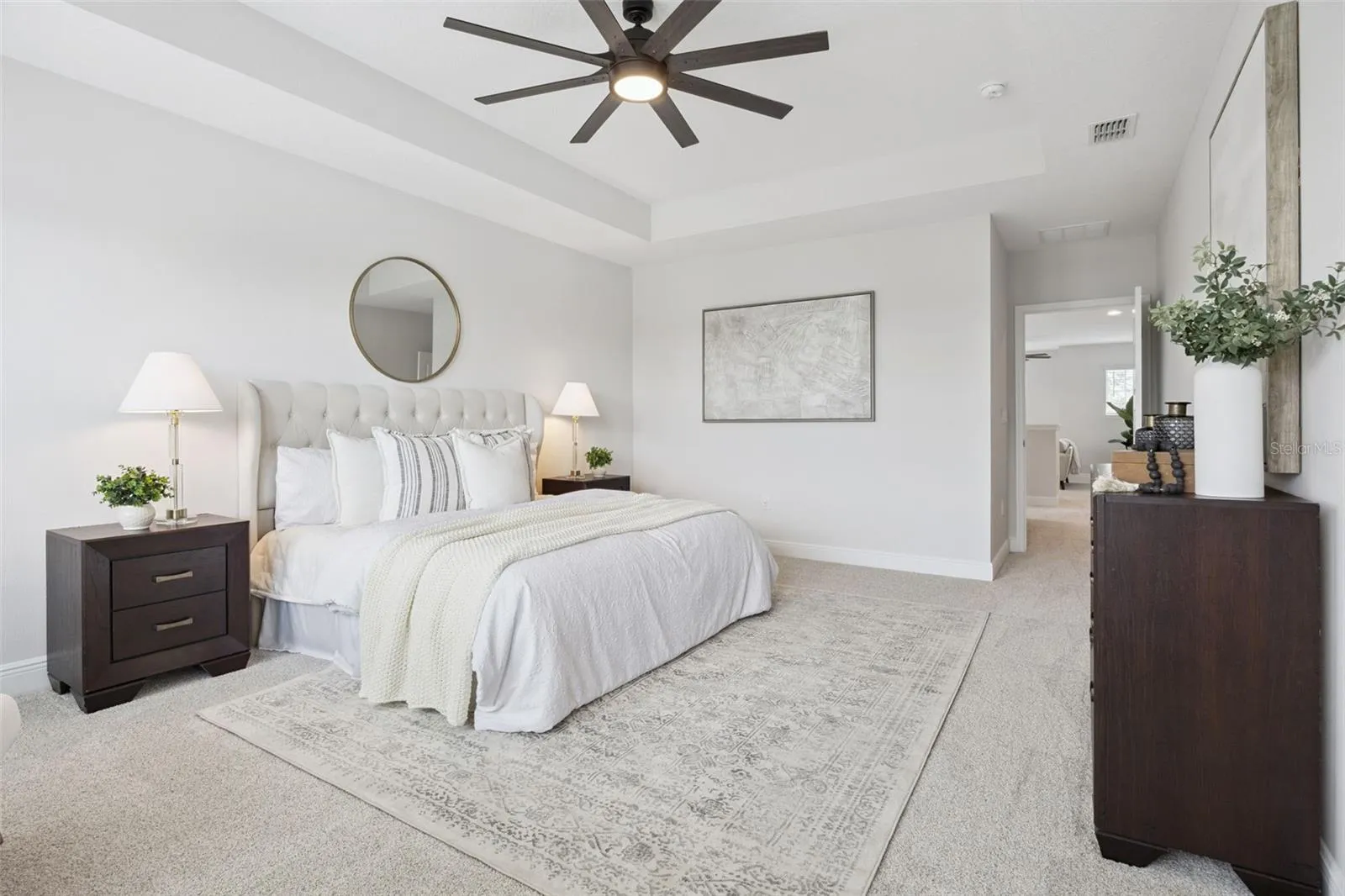 Primary bedroom with tray ceiling and en suite bath