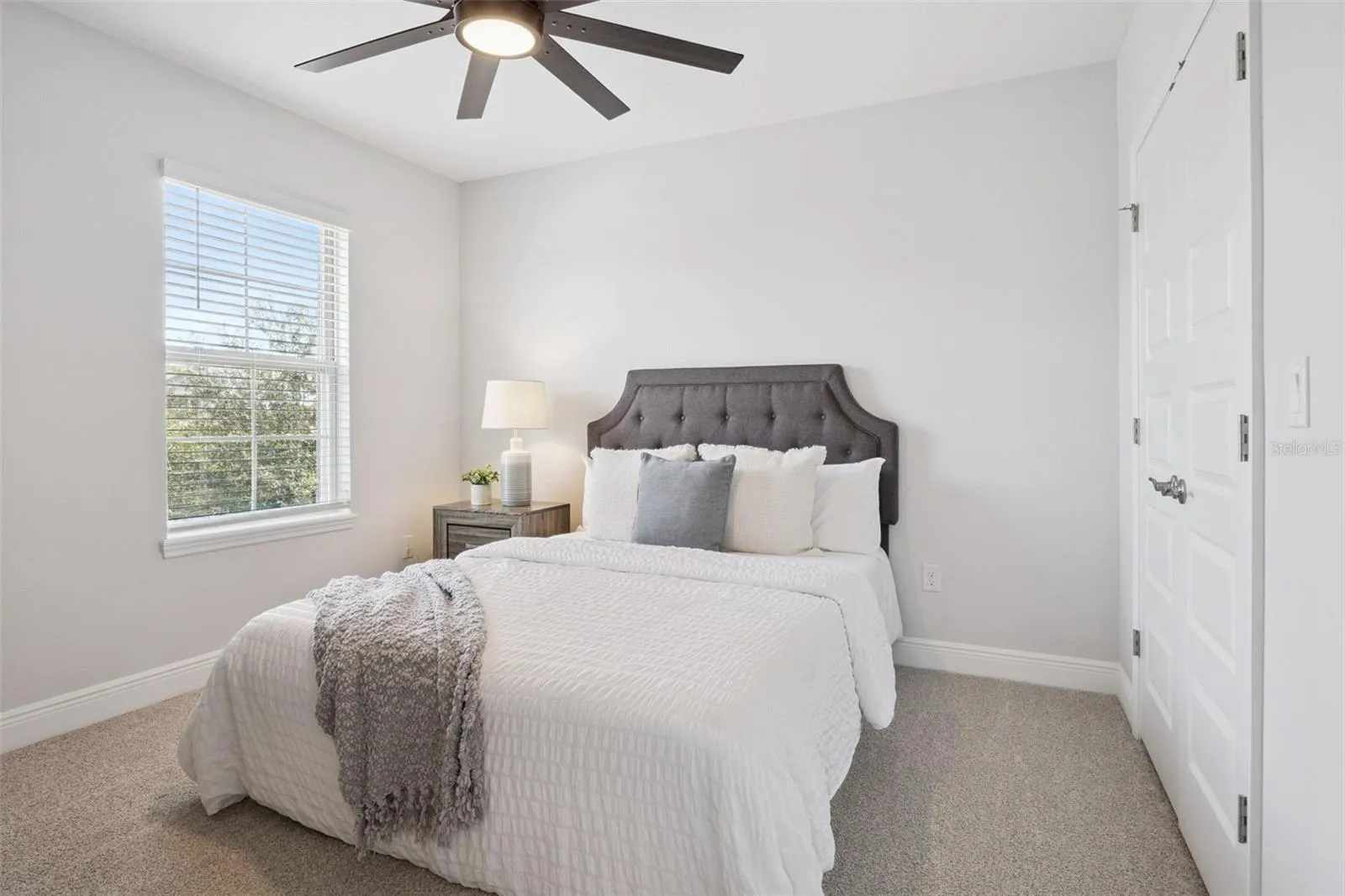 Bedroom with ceiling fan and double-door closet