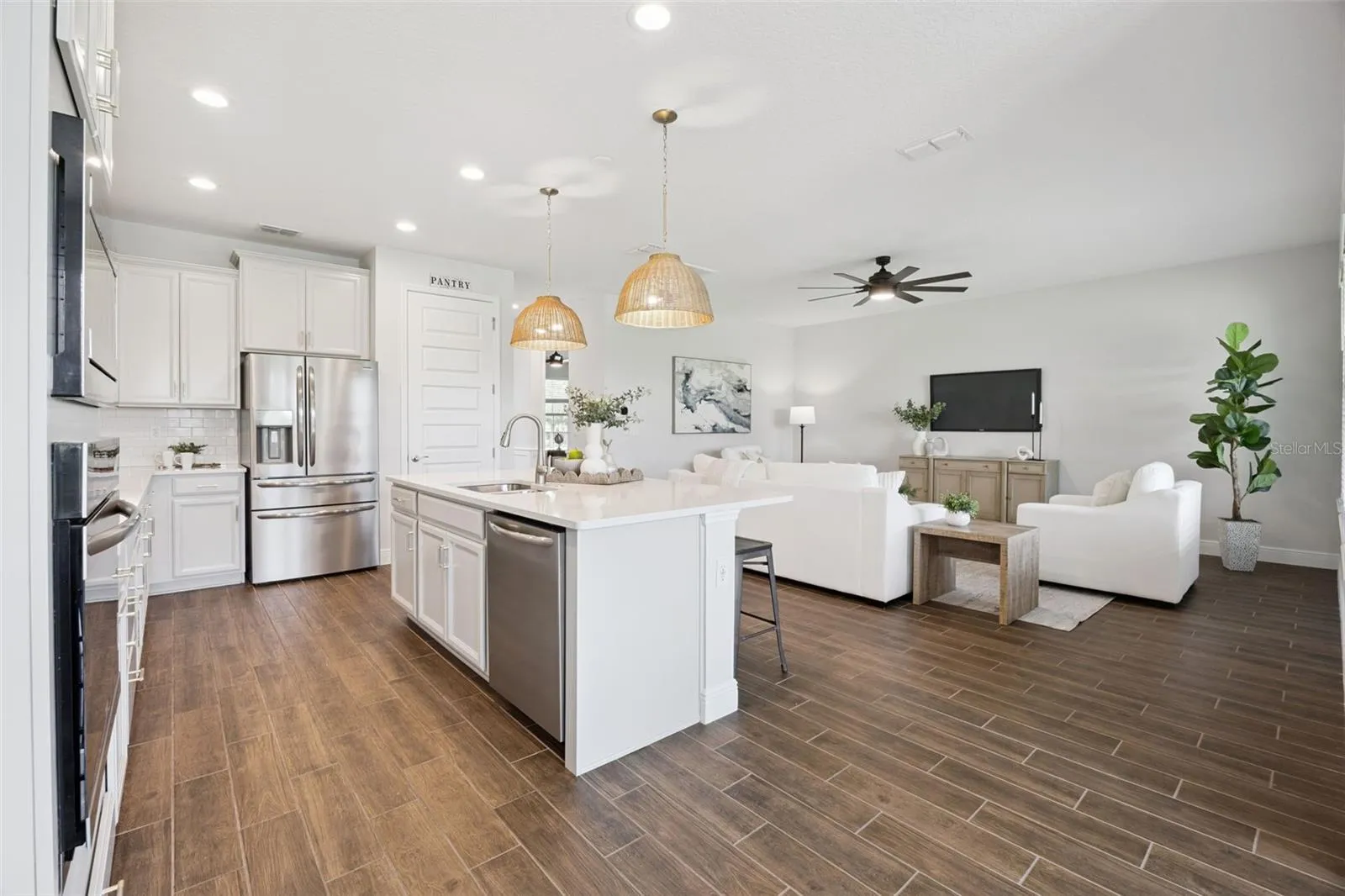 Kitchen open to the living room with wood-look tile throughout the first floor