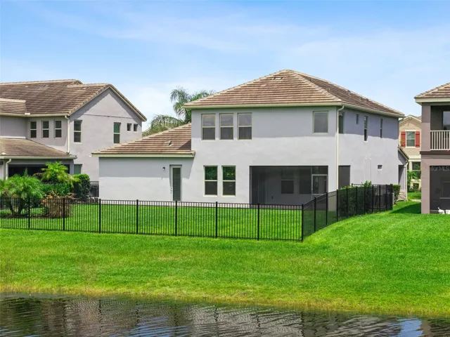 Rear exterior with fenced backyard and pond frontage