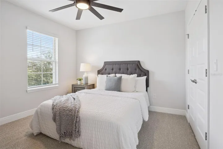 Bedroom with ceiling fan and double-door closet
