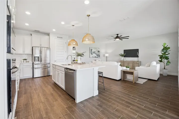 Kitchen open to the living room with wood-look tile throughout the first floor