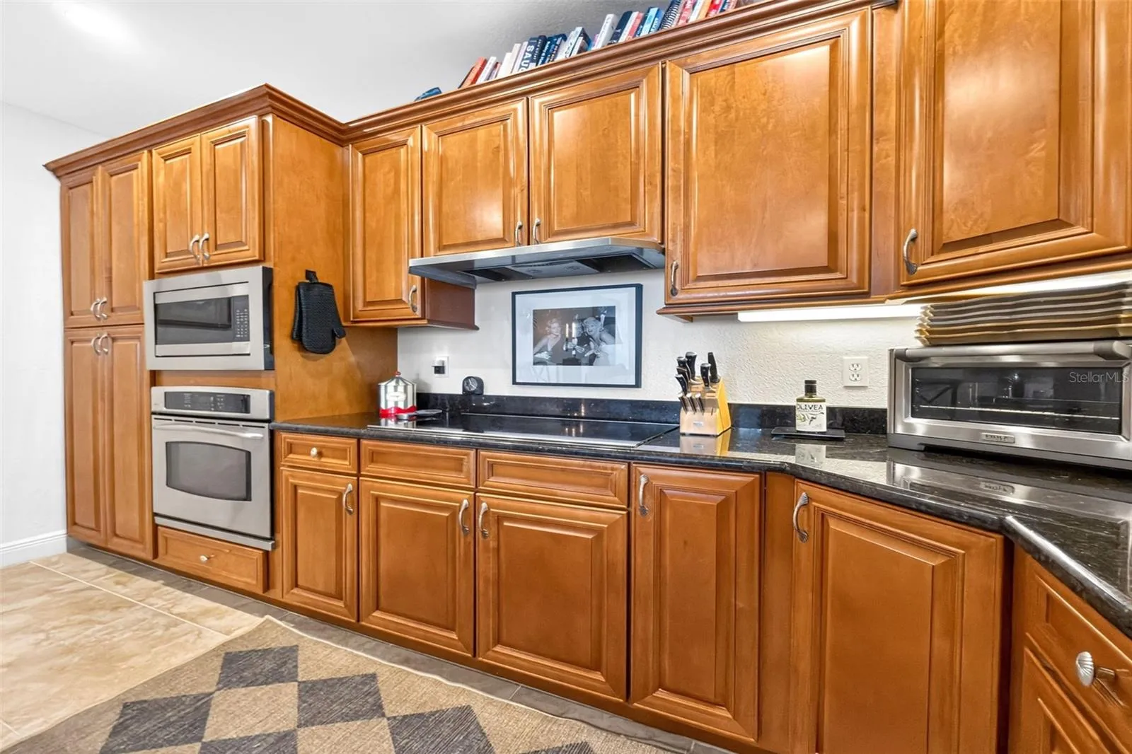 An exceptionally well- designed kitchen features induction cooktop, wall oven and microwave