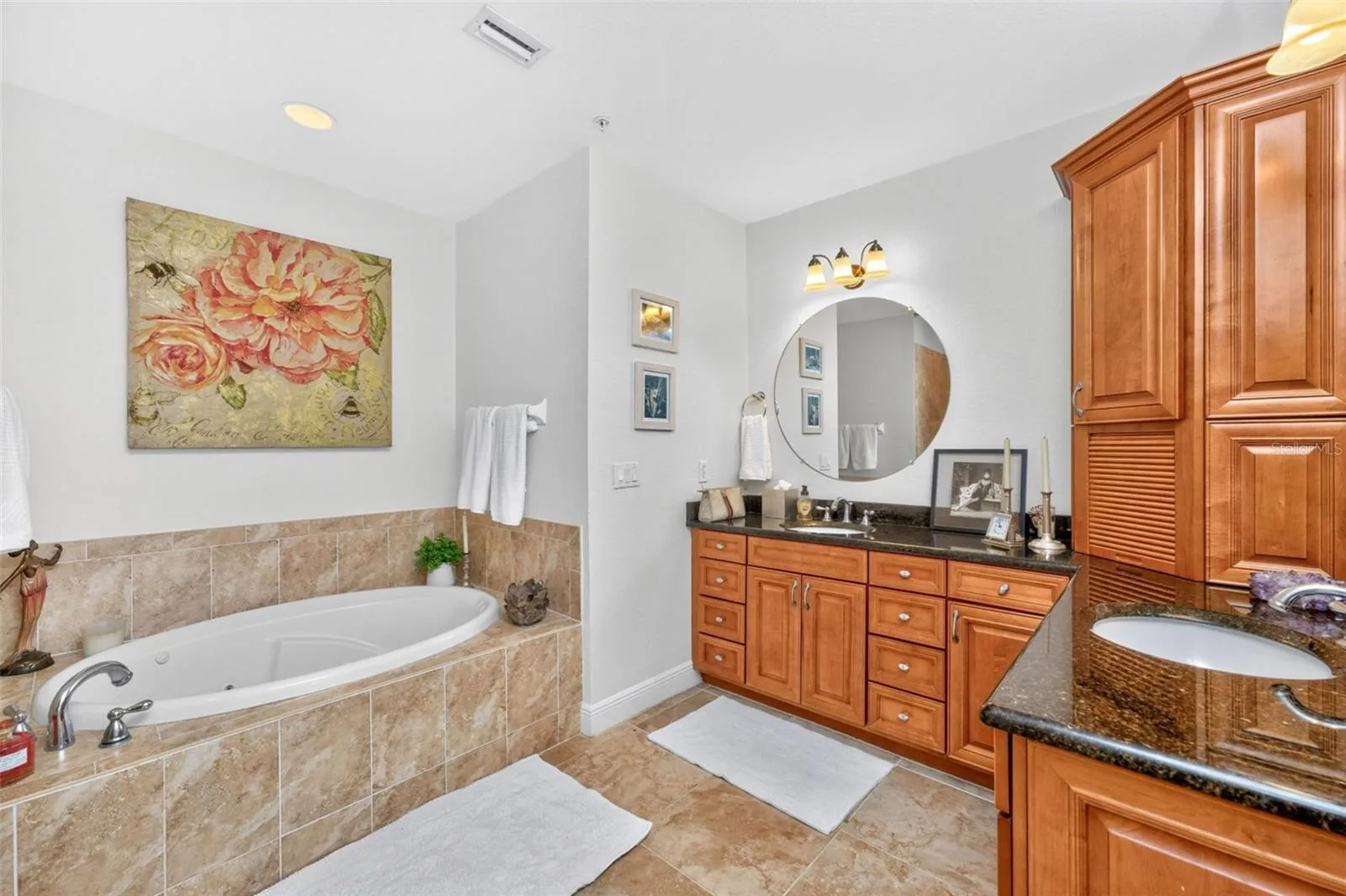 Dual vanities, jetter tub create a spa like vibe  finished with solid wood soft cabinetry with linen closet.
