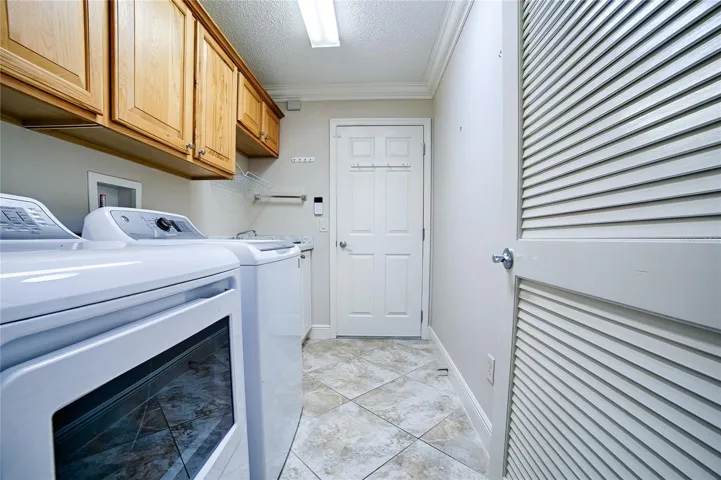 Washer Dryer room and mud sink near door to garage