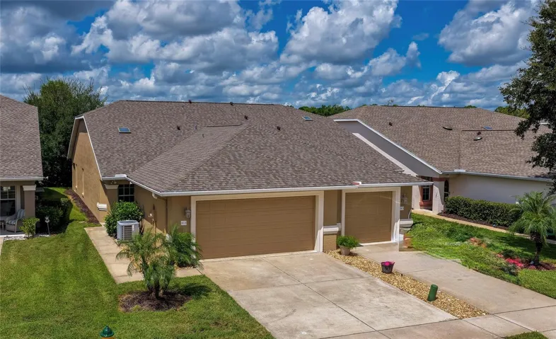 Charming home showcasing clean stucco finishes, attached garage , and a spacious concrete driveway. Simple, low-maintenance landscaping and lush green lawns complete the inviting curb appeal.