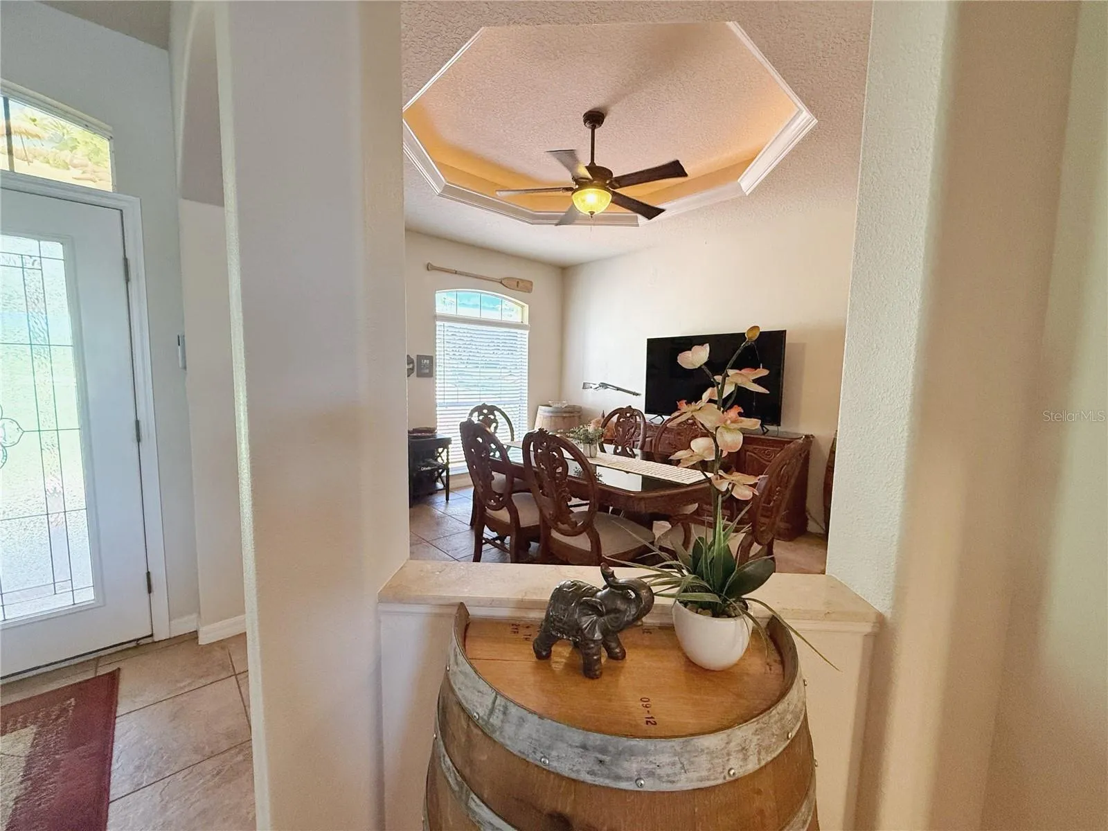 Cut out between Family room and Dining room with Entry in background, ceramic tile flooring, tray ceiling with ambient lighting