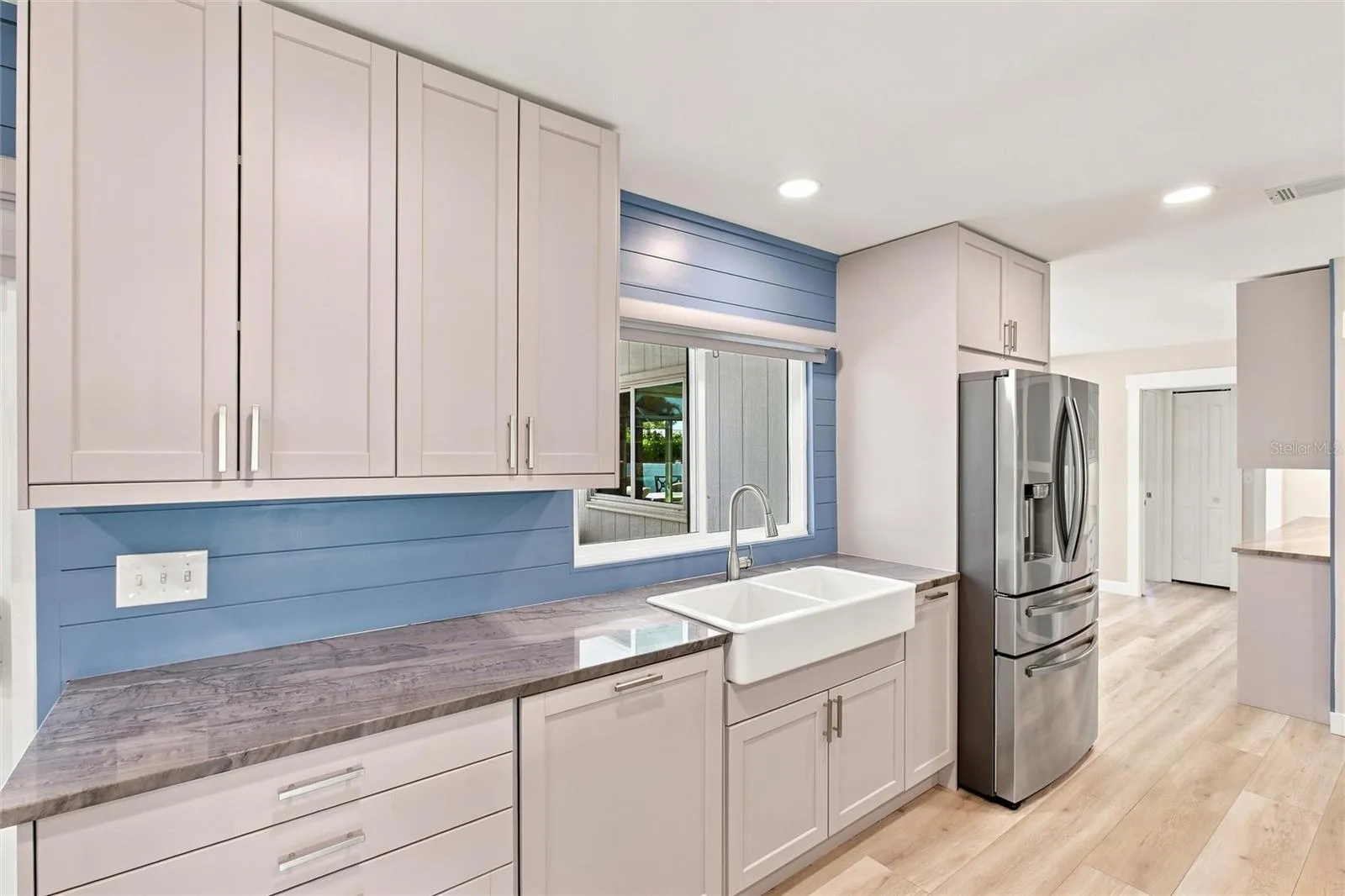Kitchen (dishwasher with cabinetry cover, farm sink, stainless steel refrigerator)