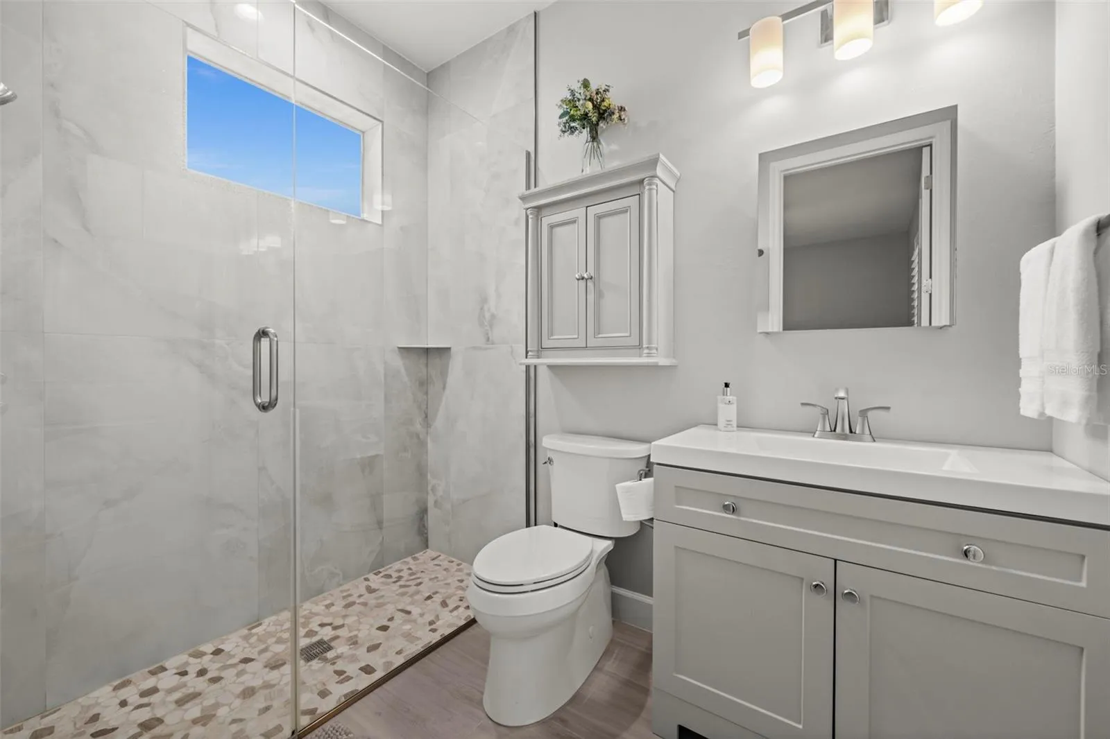 Bathroom No. 2 offers an expansive walk-in shower and a private exit to the oversized lanai.