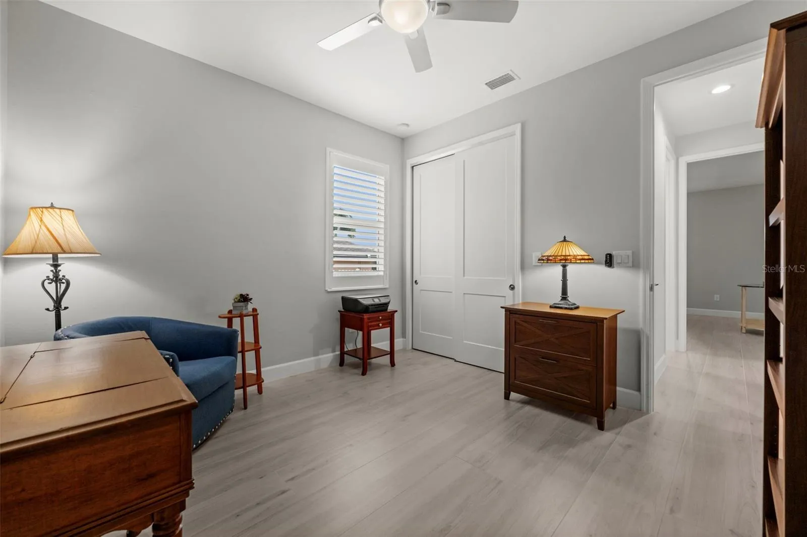 Bedroom No. 3 also has a walk-in closet, a decorative fan, and plantation shutters.