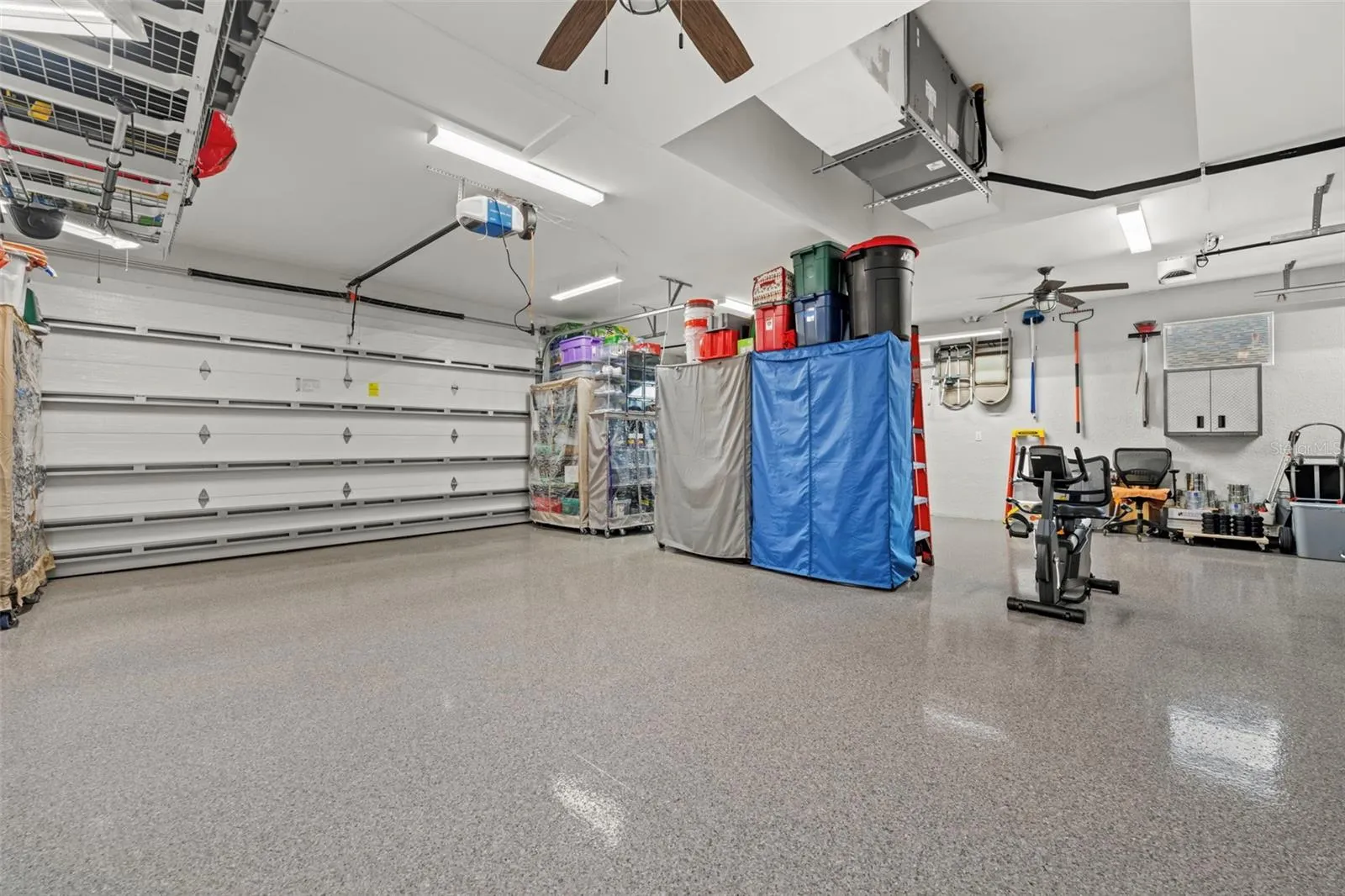 Two 8' garage doors with added insulation. There's a mini-split AC. And; notice the shining 5 coated floor.
